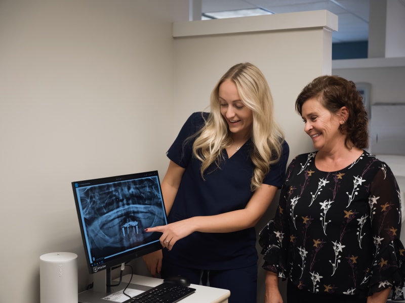 Dentist reviewing X-rays with patient at 207 Dental